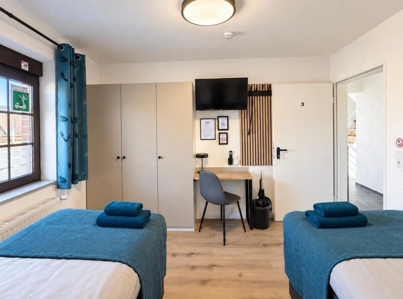 Zimmer mit zwei Einzelbetten, Schreibtisch und Schränken